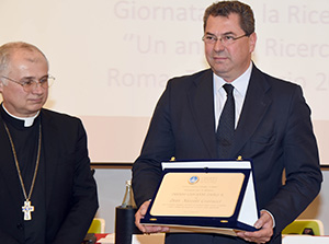 La consegna del premio a Niccolò Contucci di Airc da parte di monsignor Claudio Goiuliodori