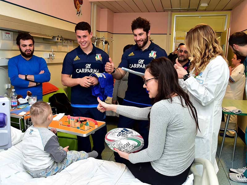 I giocatori della nazionale italiana di rugby con un piccolo paziente del Gemelli